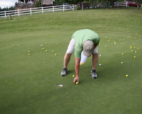 Brent Dehlbom, member of Fry Healthcare Foundation Board of Directors picks up the winning golf ball.